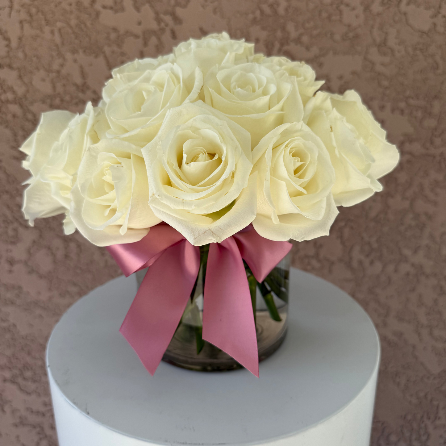 Floral arrangement with white roses in glass vase.
