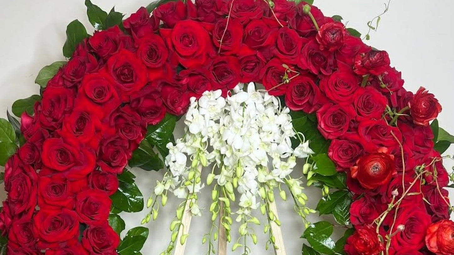Floral wreath with red roses and white flowers on a light background