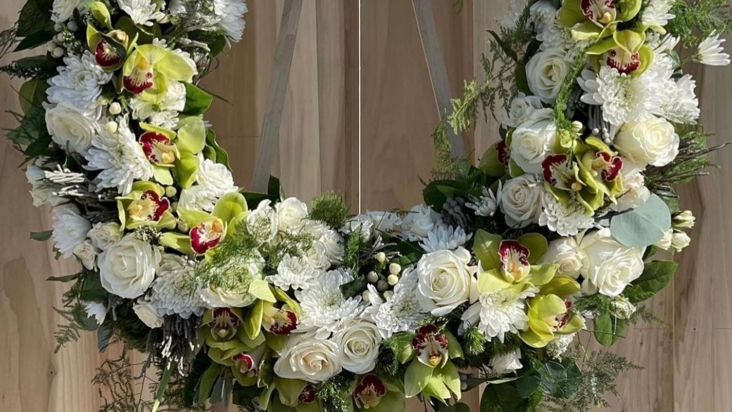 Floral wreath with green and white flowers on a wooden background