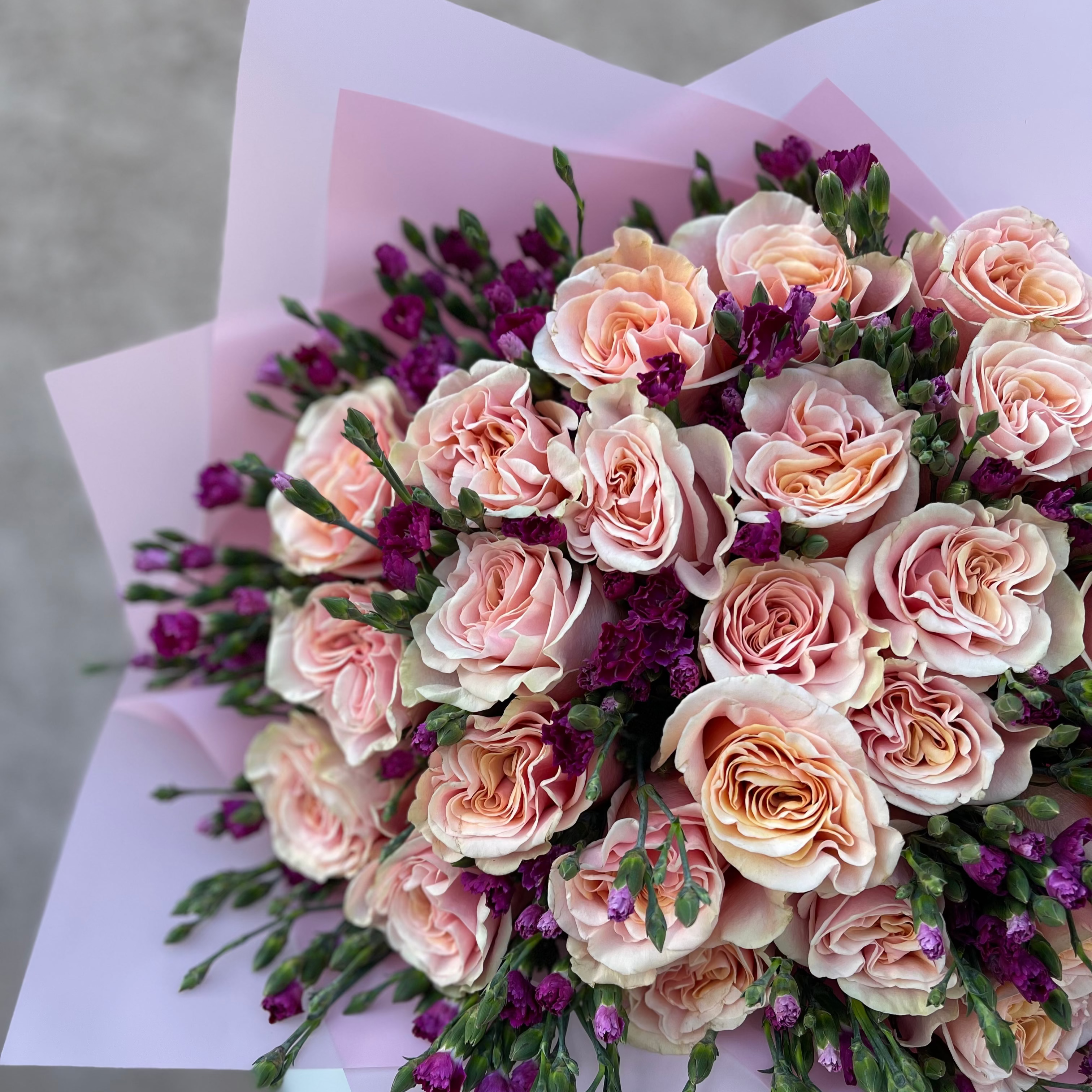 Bouquet of pink and purple flowers on a light gray background