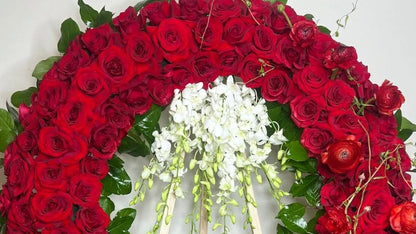 Floral wreath with red roses and white flowers on a light background